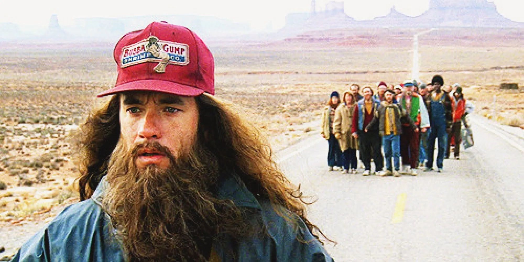 Forrest stops on his run with a crowd behind him in Forrest Gump