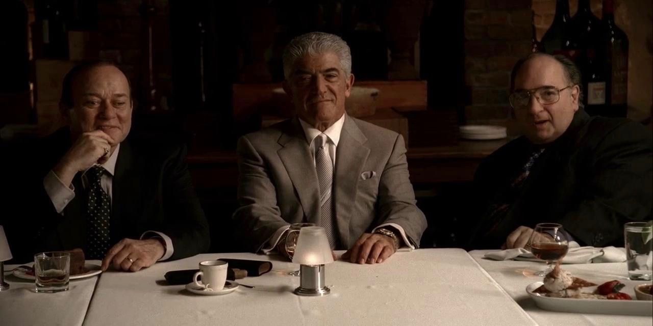 Phil sits at a table surrounded by two men in The Sopranos