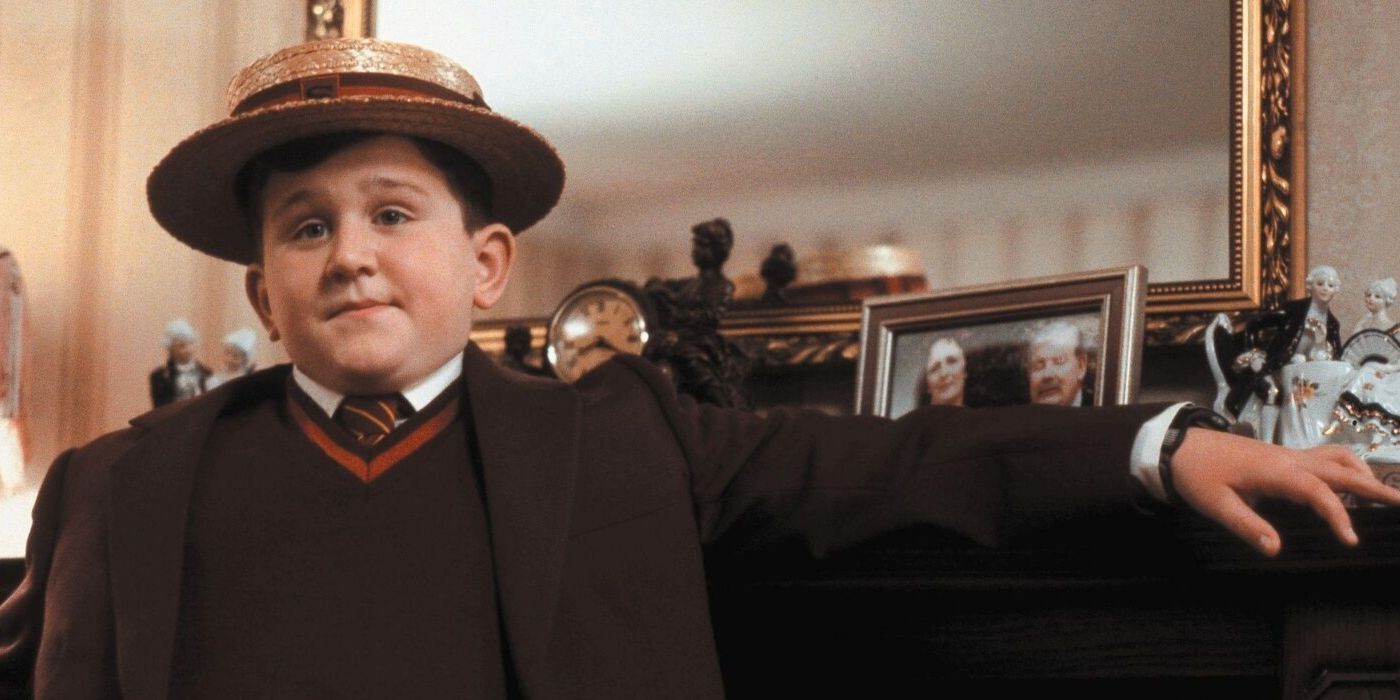 Dudley Dursley in Harry Potter with a bowler on leaning on the mantle.