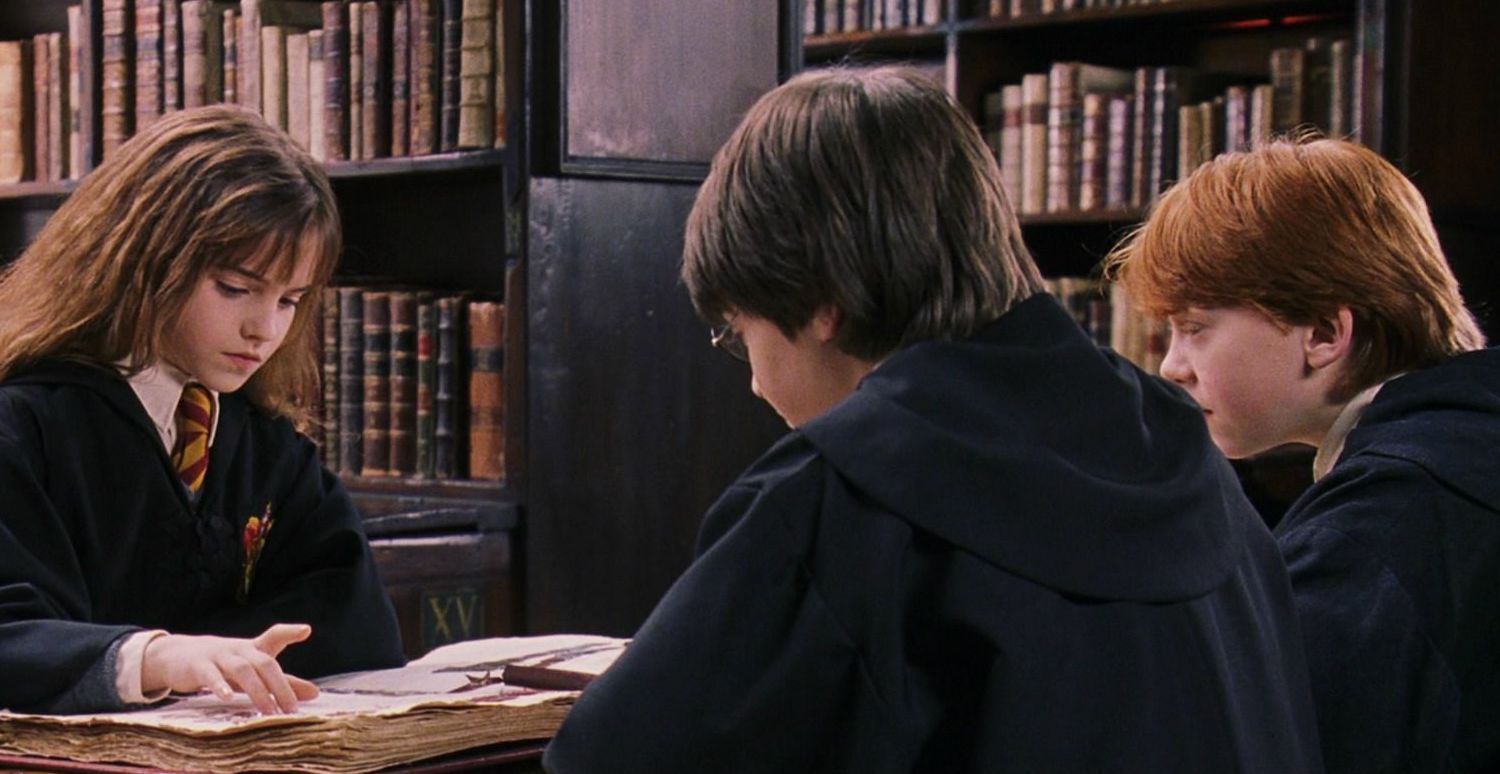 Hermione, Harry, and Ron studying in the library in Harry Potter