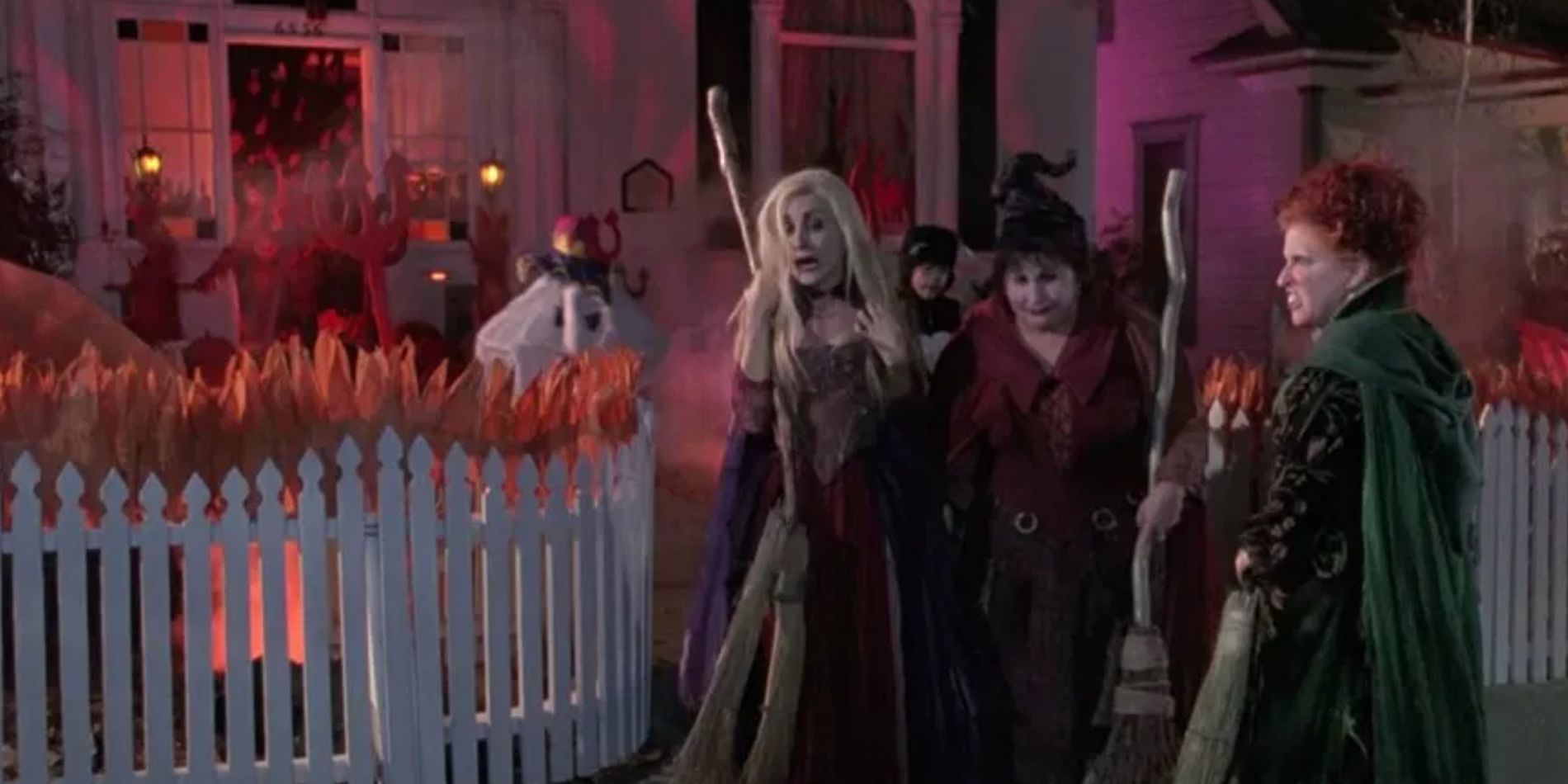 Sarah, Mary, and Winifred Sanderson outside a house while kids trick-or-treat in Hocus Pocus