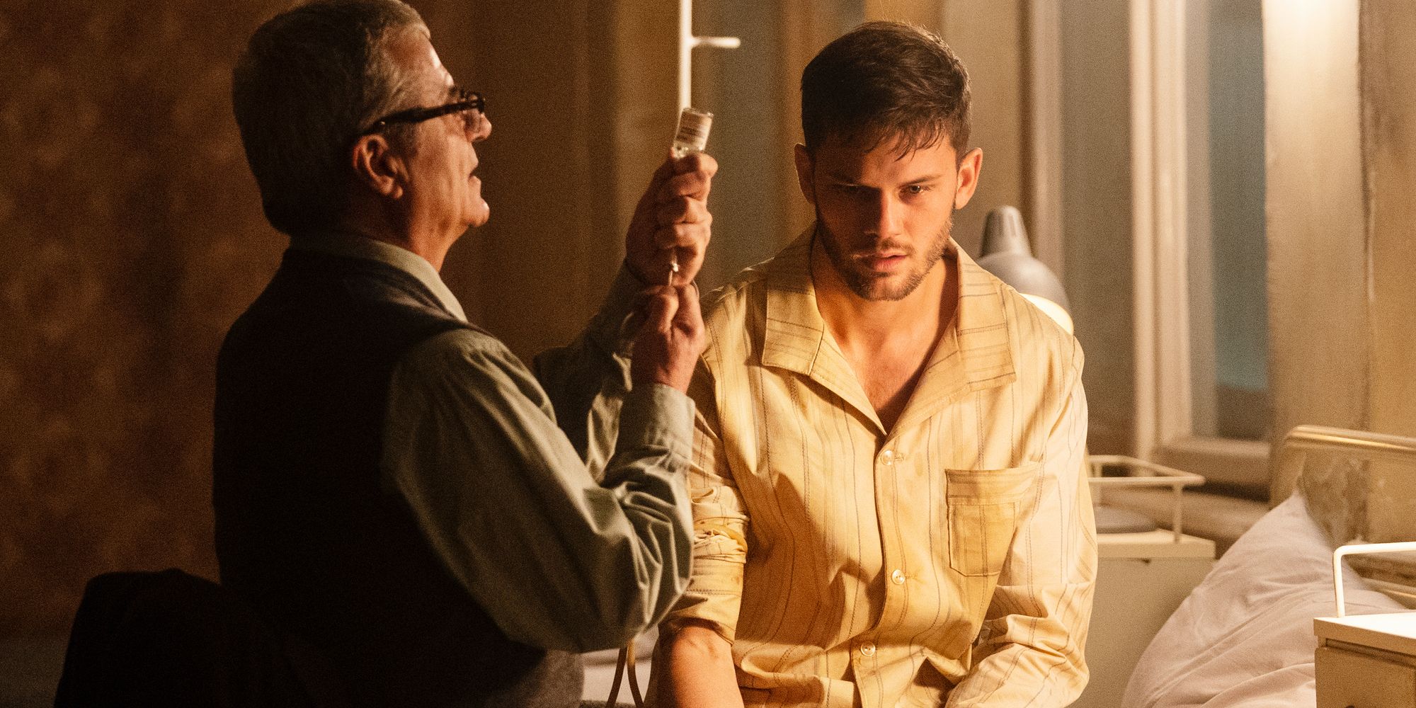 Jeremy Irvine on a hospital bed being treated by a doctor in Treadstone