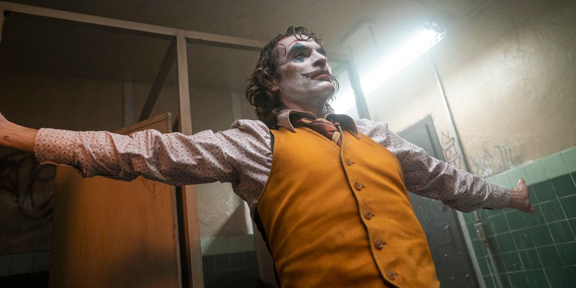 Joaquin Phoenix as Joker with his arms spread wide