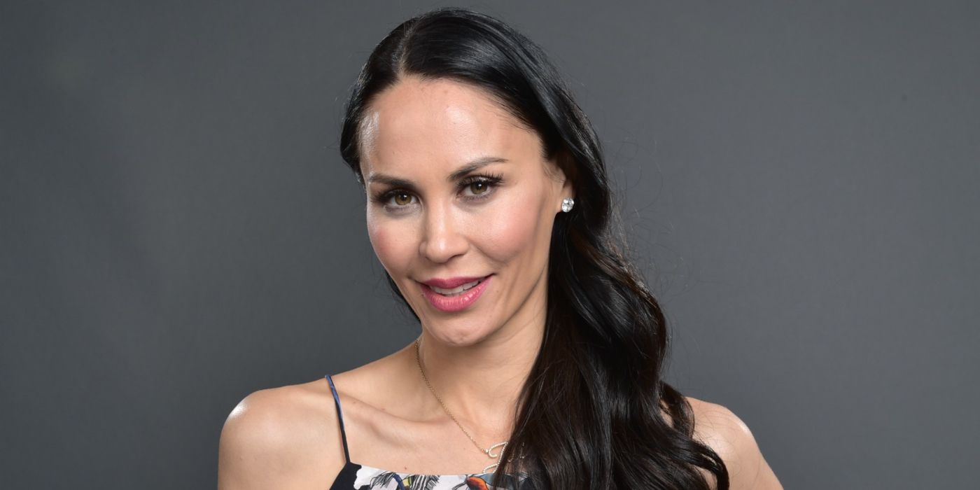 Jules Wainstein smiling for the camera while standing in front a grey background