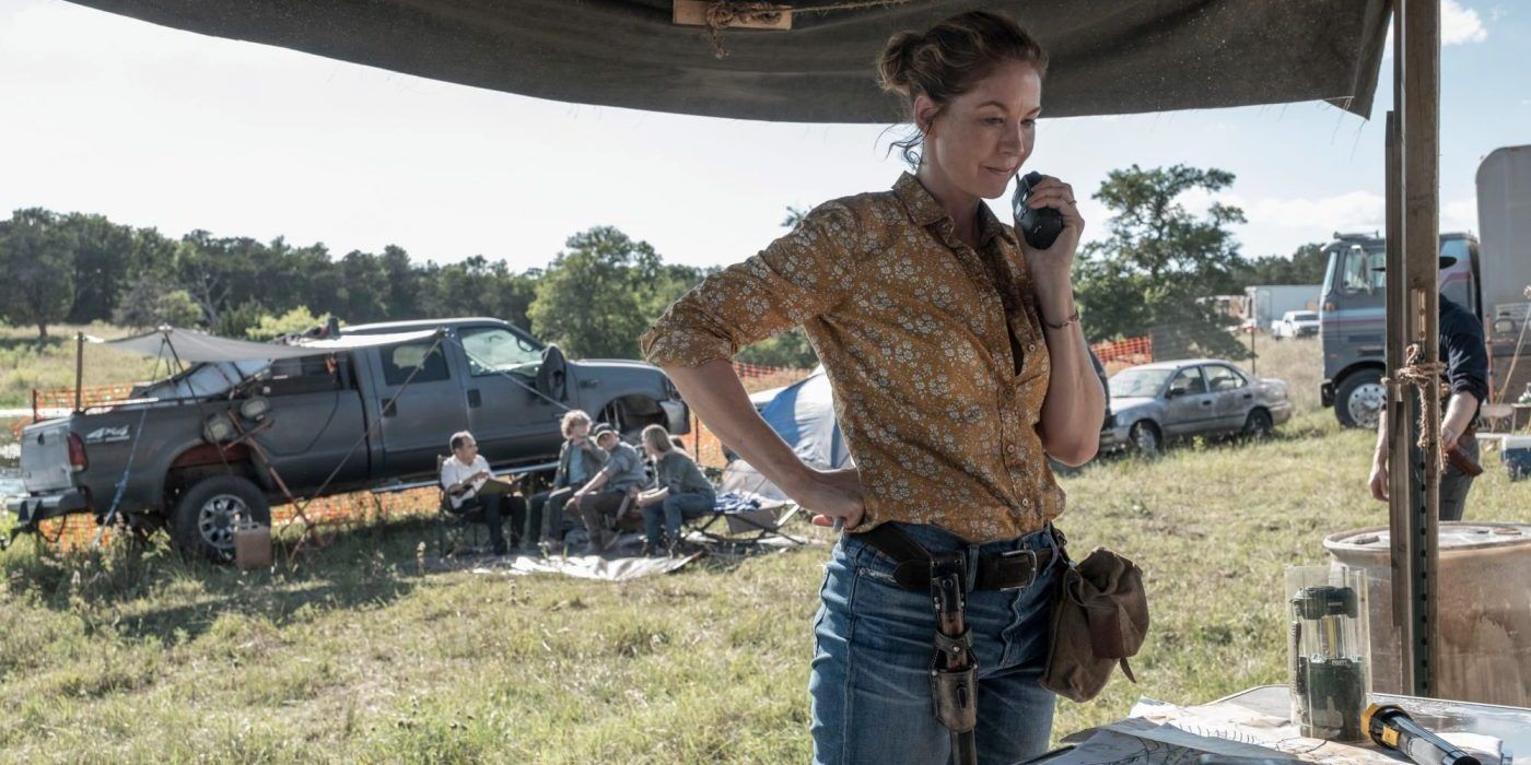 June from Fear the Walking Dead, standing in a field, holding a walkie-talkie.