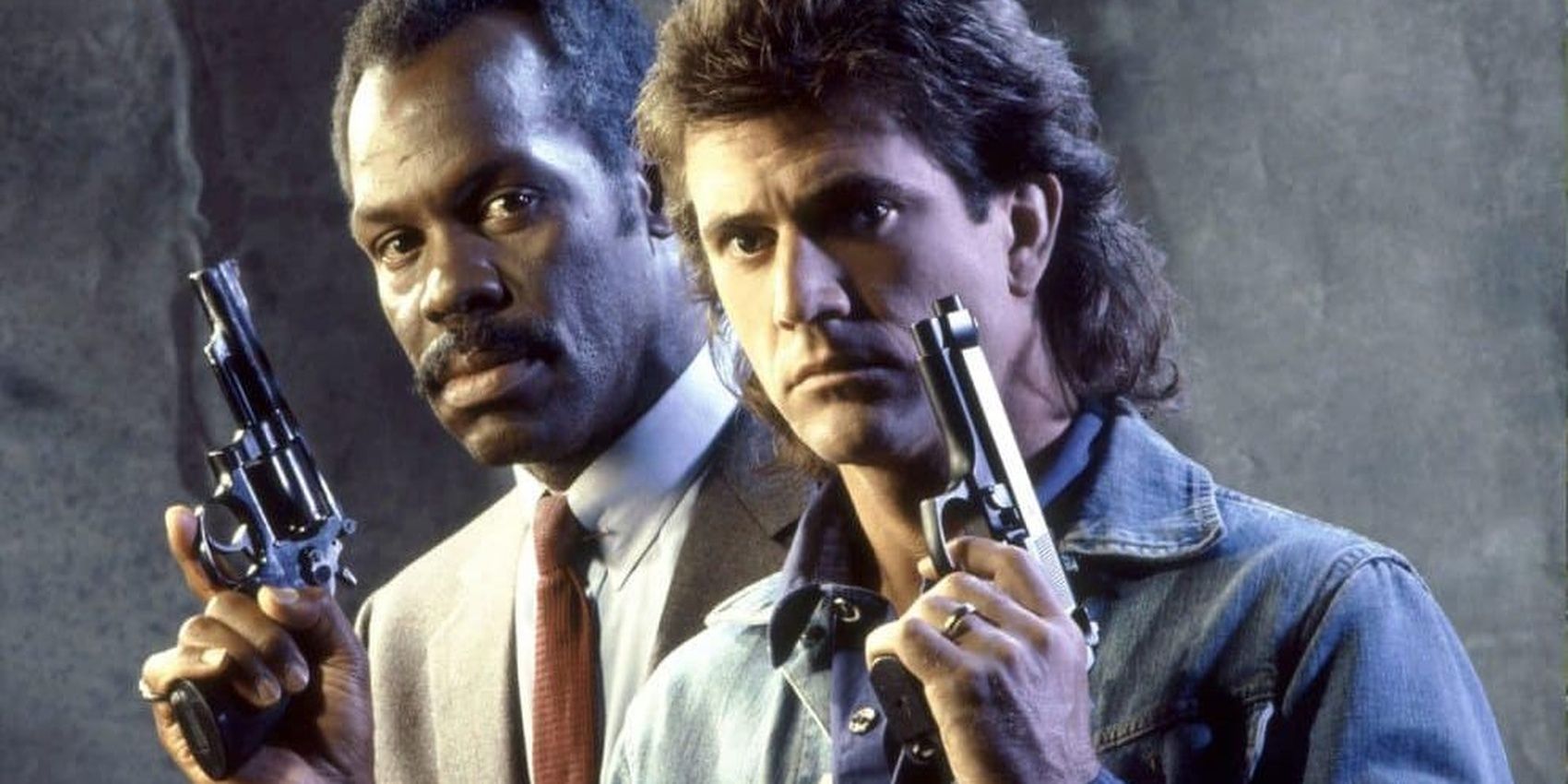 Mel Gibson and Danny Glover holding guns in Lethal Weapon 