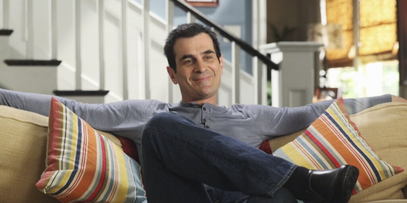 Phil assis sur le canapé de Modern Family