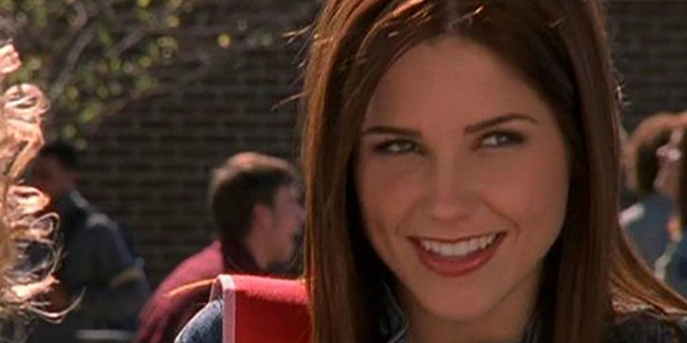 Brooke Davis sorri no pátio da Tree Hill High