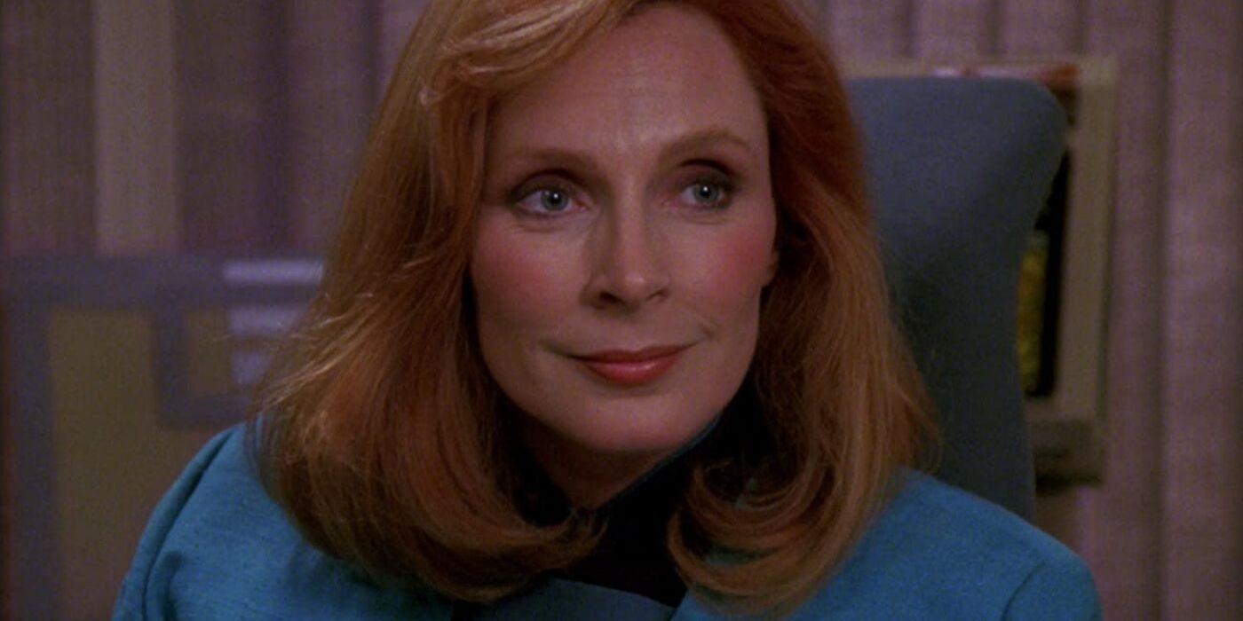 Doctor Crusher flashes a concerned smile.