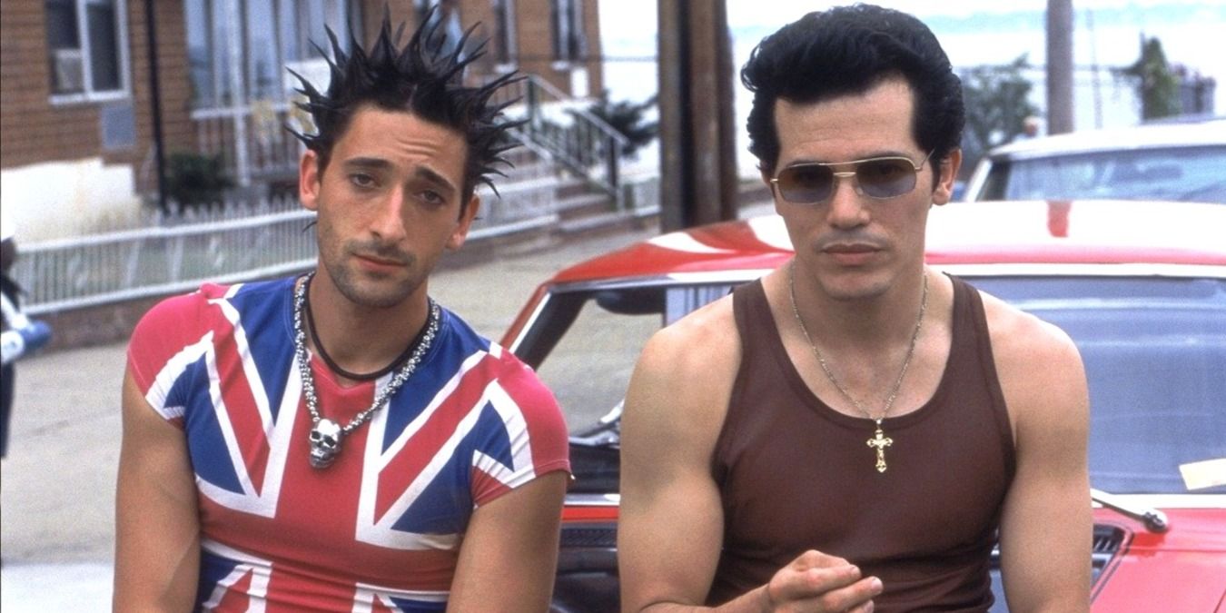 Adrein Brody and John Leguizamo leaning against a car in a still from Summer of Sam 