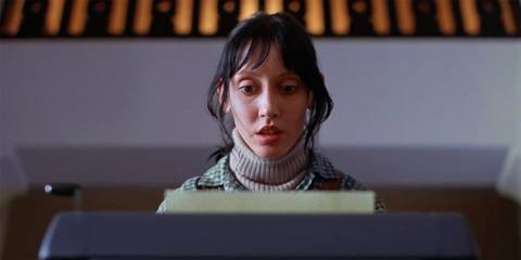 Shelley Duvall as Wendy Torrance looking shocked at the typewriter in The Shining
