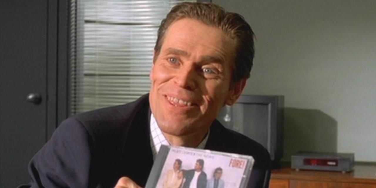 Willem Dafoe holding a Huey Lewis CD