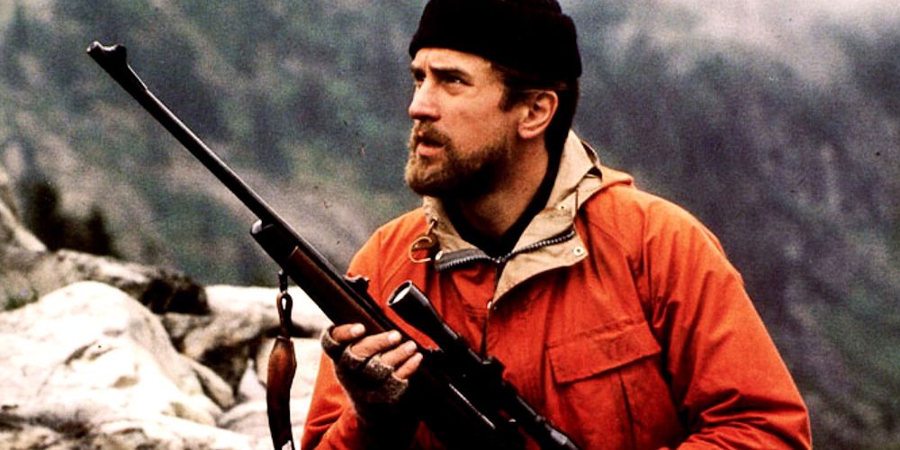 Robert De Niro treks through the woods with a rifle from The Deer Hunter