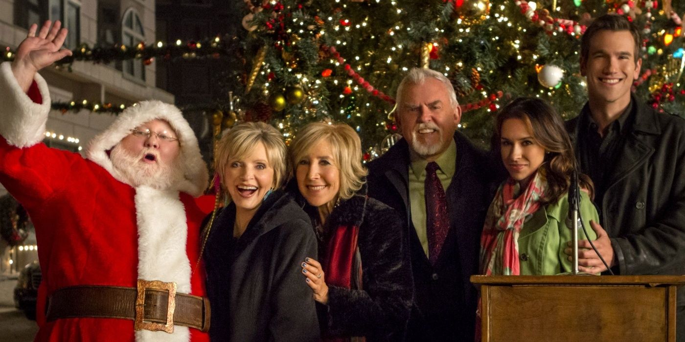 The main characters with Santa in front of a Christmas tree on Matchmaker Santa 