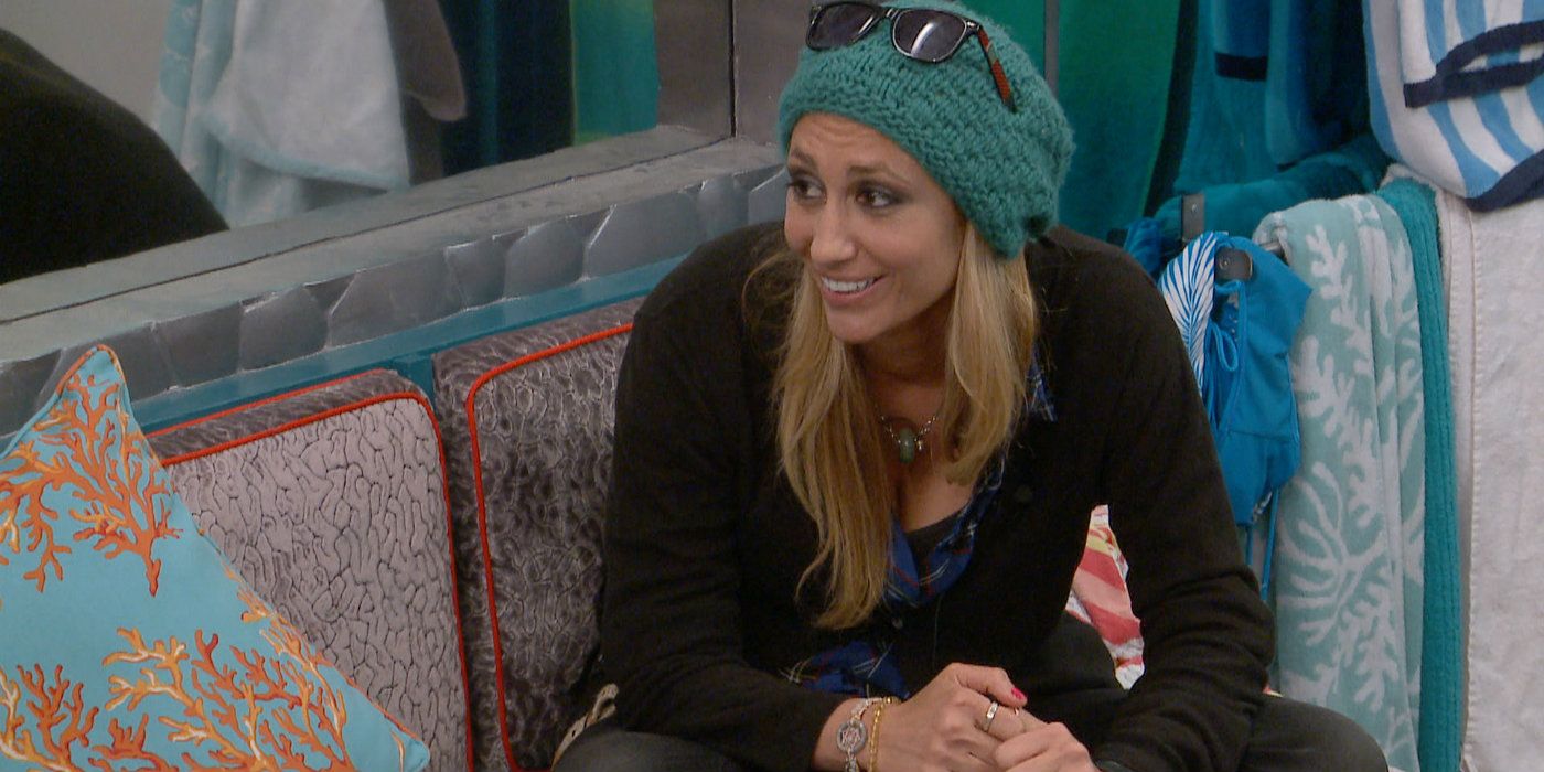 Vanessa from Big Brother sitting down with a toque, smiling and looking at someone to the left.