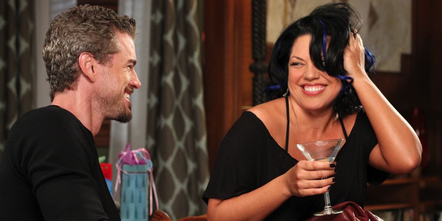 Callie holding A drink and smiling at Mark in Grey's Anatomy