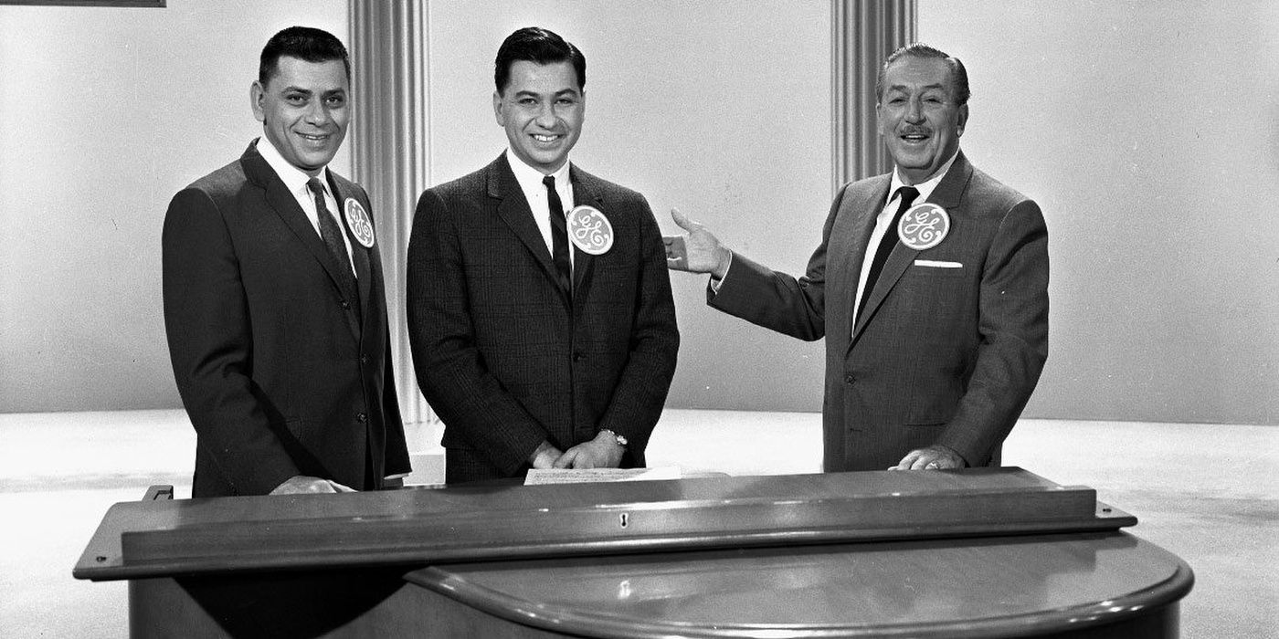 Disney poses with the Sherman Brothers at a piano