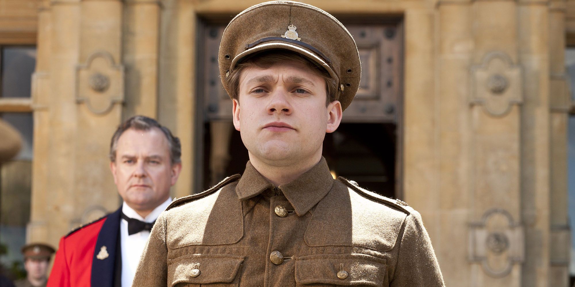 William stands in front of a manor in Downton Abbey.