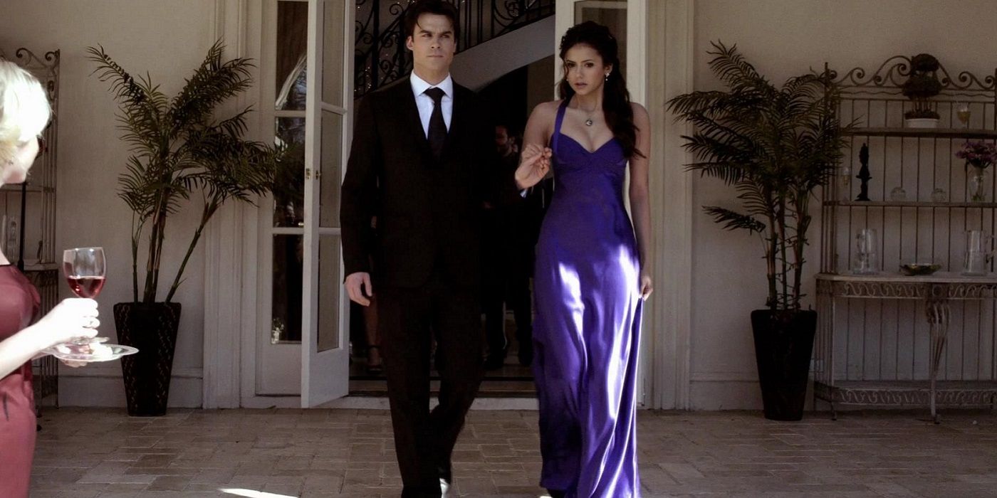 Damon and Elena walking outside in formal clothing in The Vampire Diaries