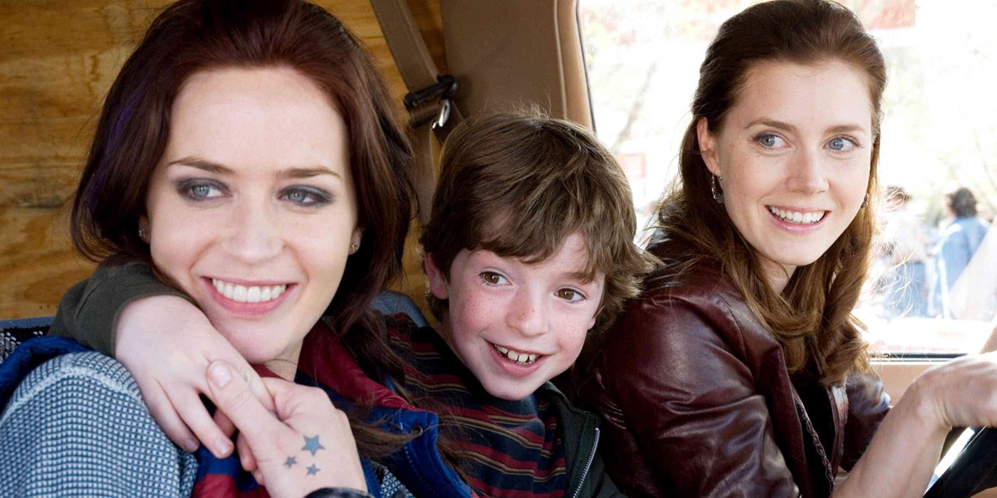 Norah, Rose and her young son smiling at someone from a car in Sunshine Cleaning