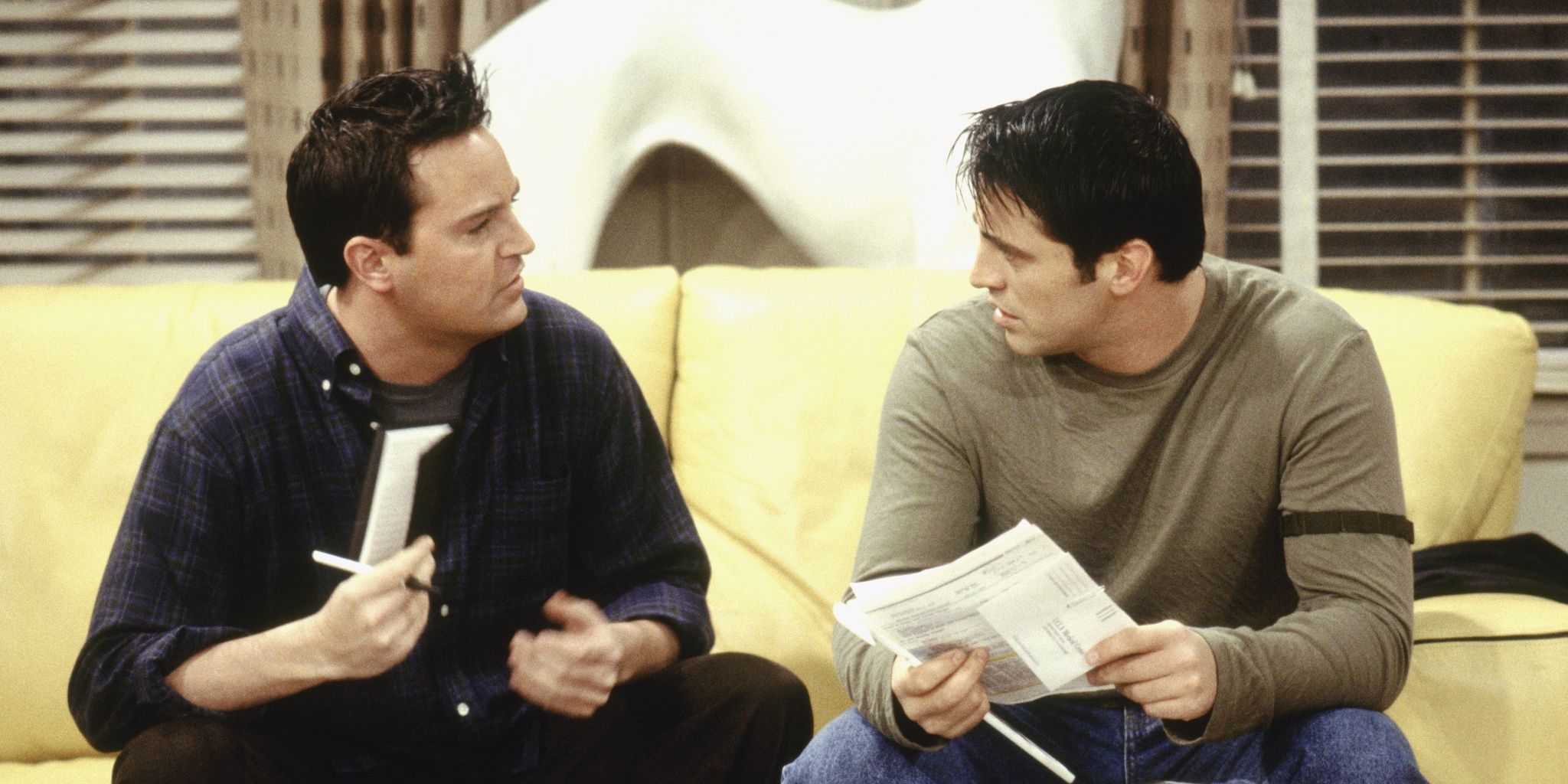 Joey and Chandler sitting on the couch in Friends.