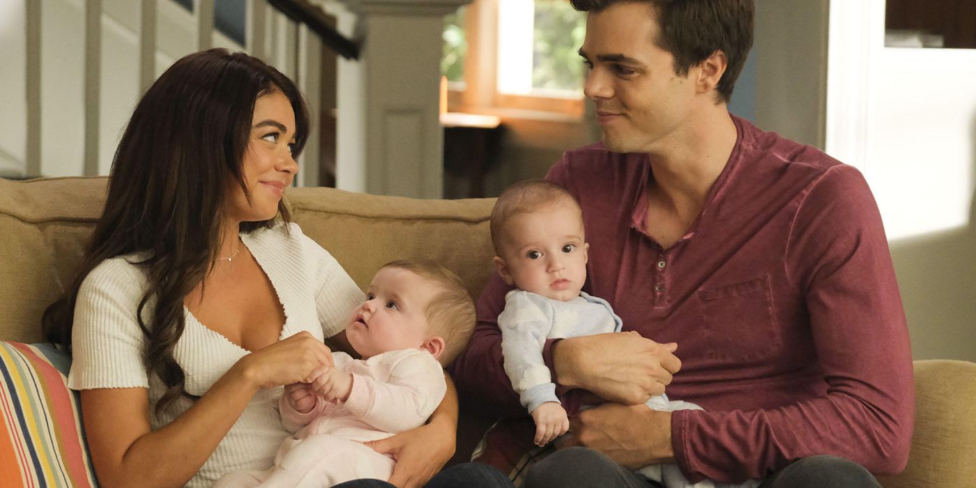 Haley and Dylan sitting on the couch with their babies on Modern Family