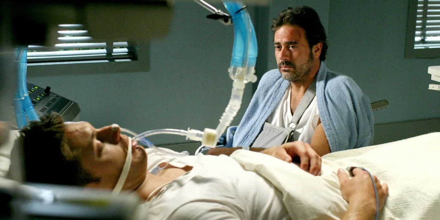 John Winchester looks on at Dean in a hospital bed