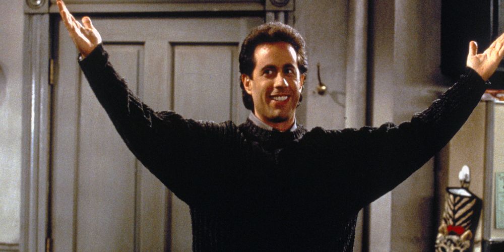 Jerry Seinfeld lifting his hands up in his apartment on Seinfeld