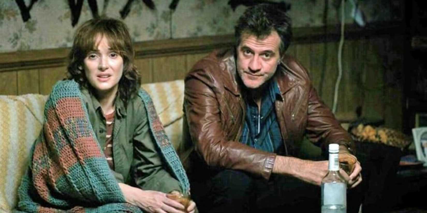 Joyce and Lonnie sitting on a couch in Stranger Things