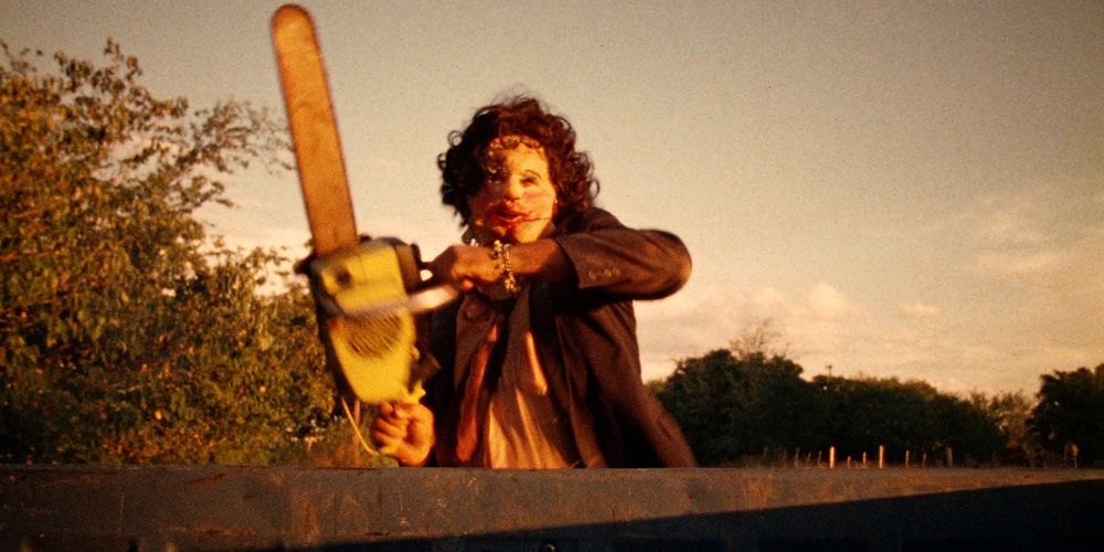 Leatherface wielding a chainsaw while running in The Texas Chainsaw Massacre.