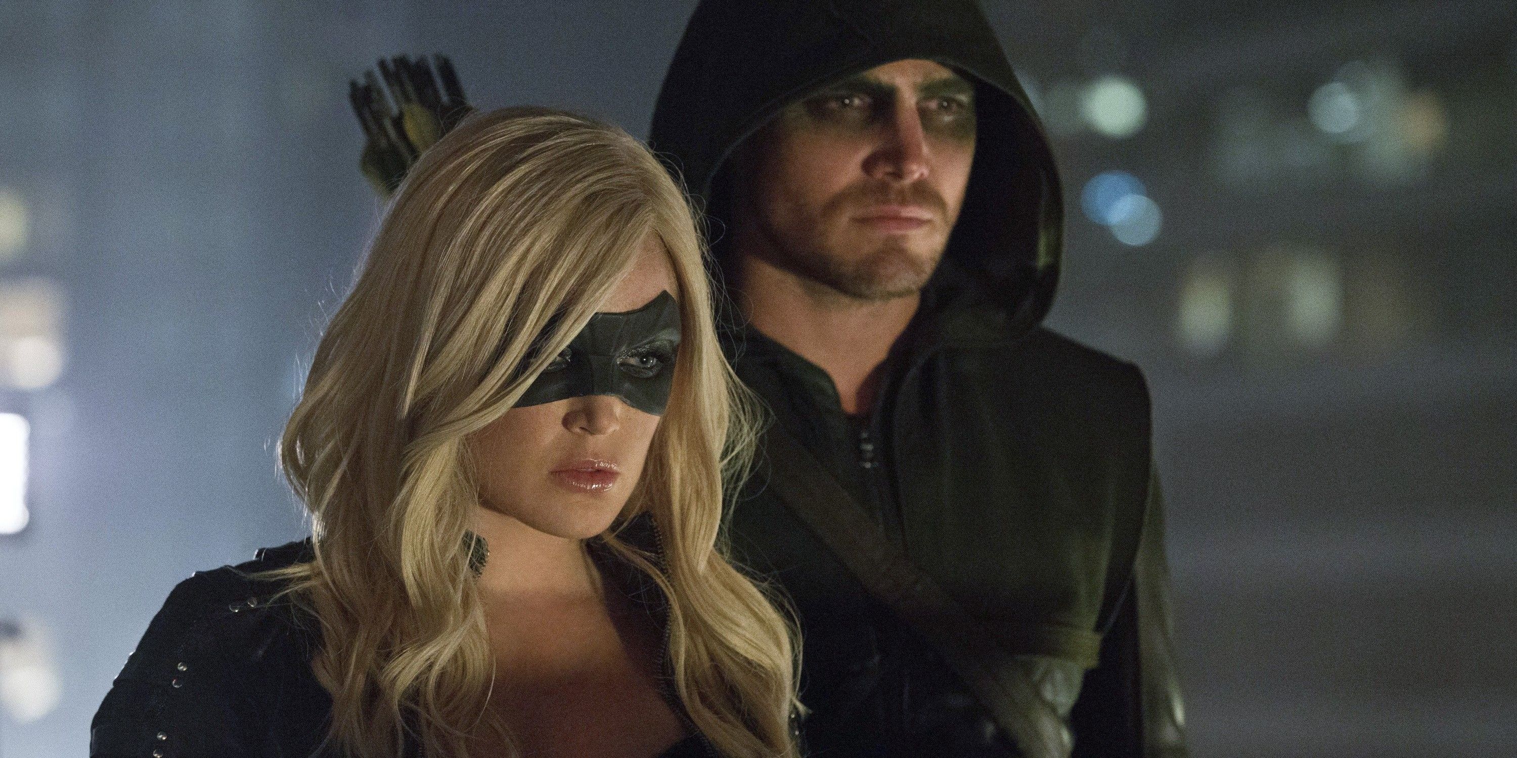 Oliver and Sara stand in their costumes on the roof in Arrow