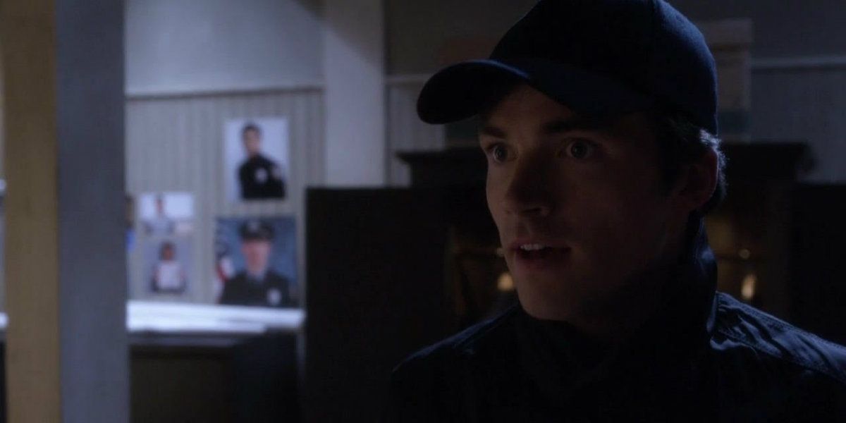 Ezra wearing a baseball cap in his lair on Pretty Little Liars