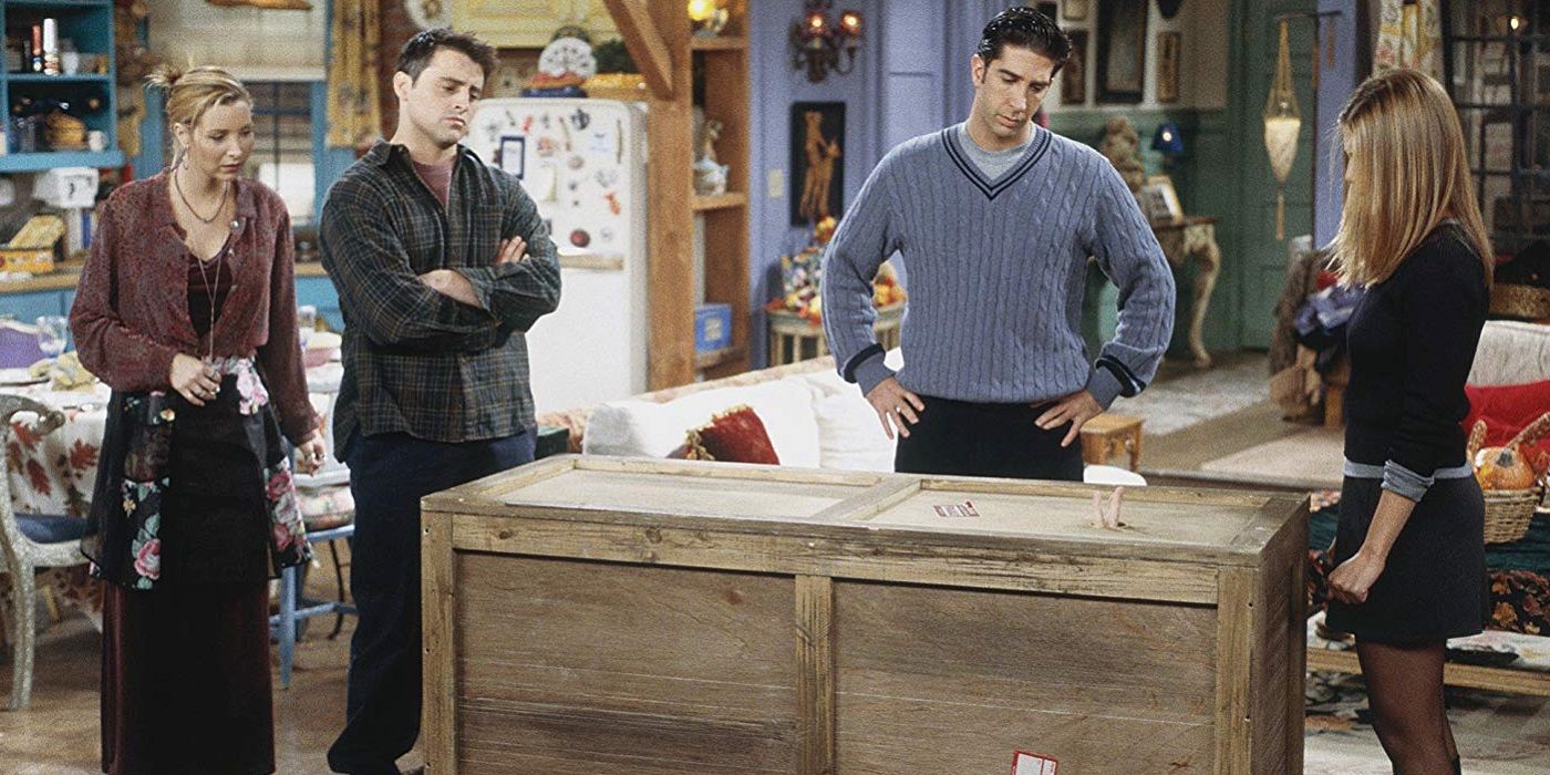 The gang standing around Chandler in a box