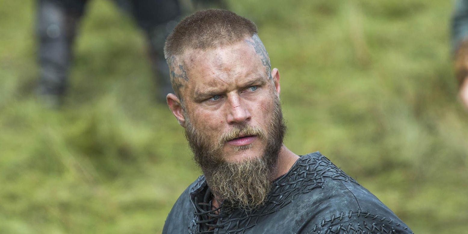 Ragnar in Vikings in battle looking off to the side with a dirty face.