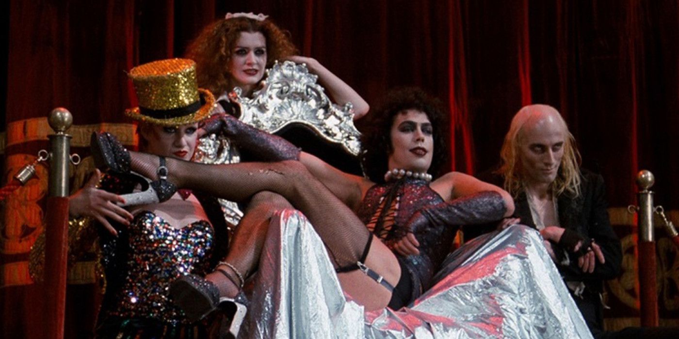 Magenta, Columbia and Riff Raff surround the throne where Dr. Frank N. Furter poses in The Rocky Horror Picture Show.