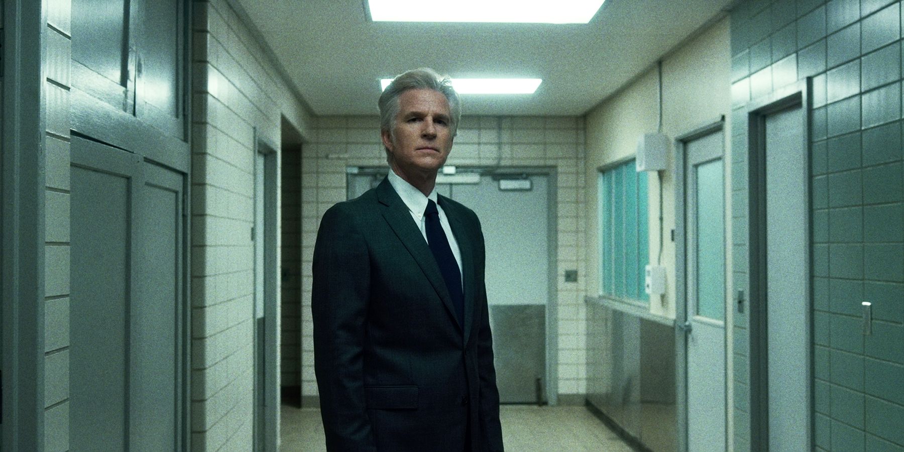 Dr Brenner standing in a hallway in Stranger Things