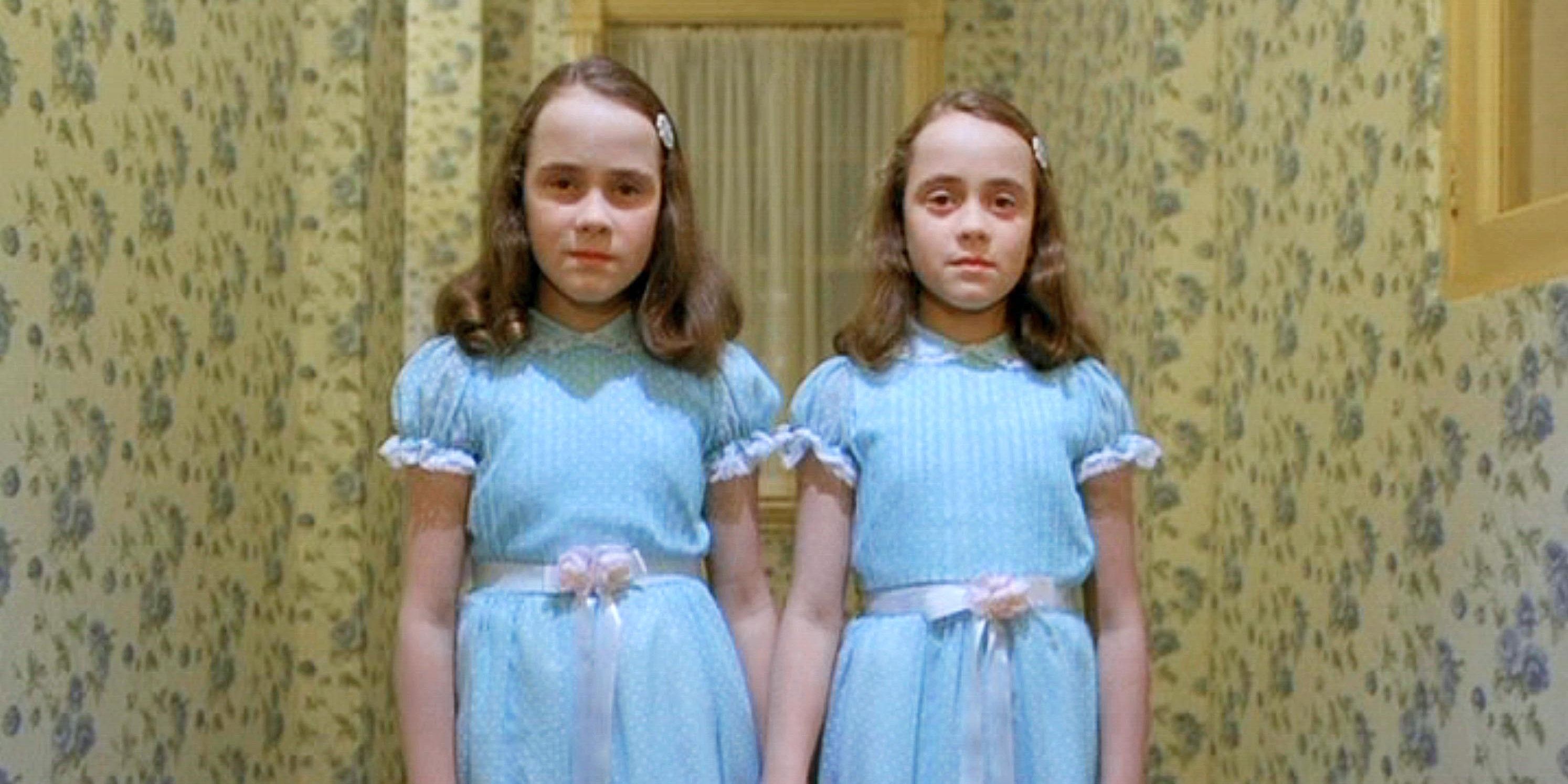 The Shining Twins holding hands in their signature blue dresses