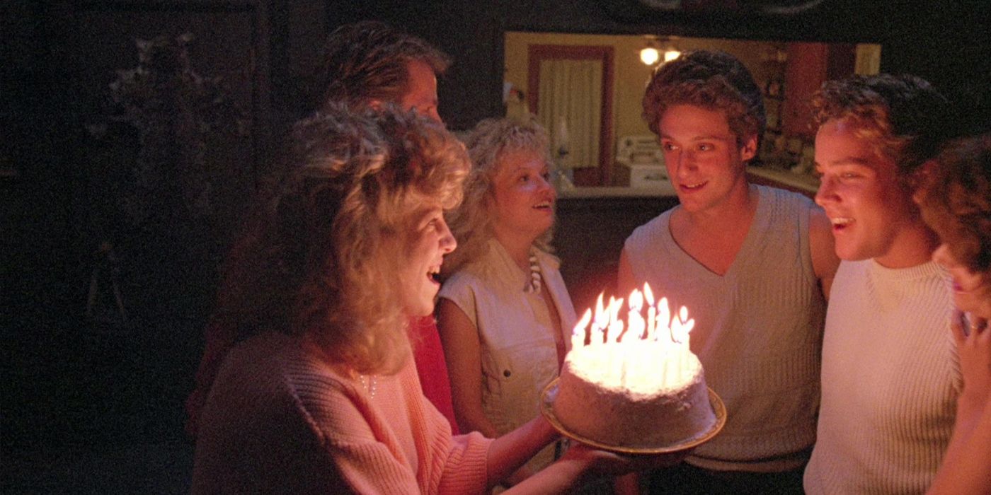 Characters stand around a cake with lit candles in the 1986 movie The Zero Boys