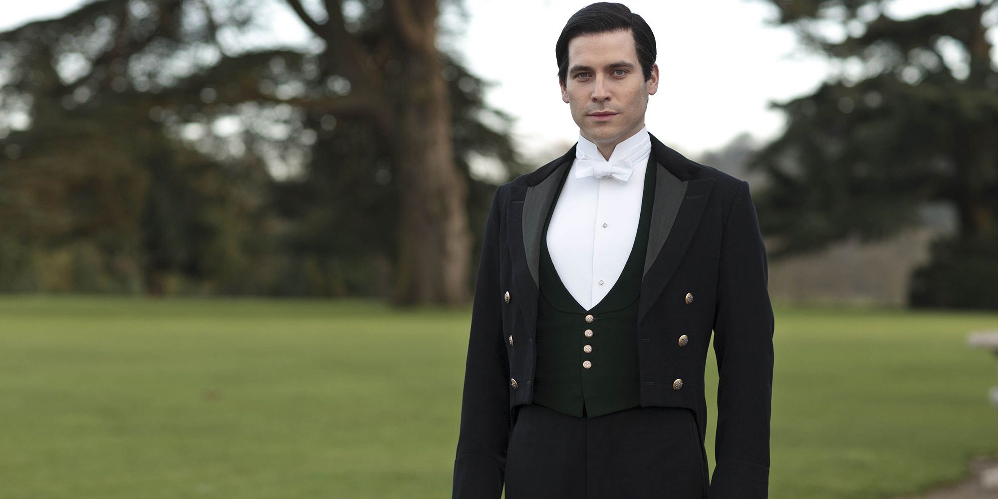 Thomas posing outside in livery in Downton Abbey