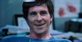 Christian Bale as Michael Burry smiling in his office in The Big Short
