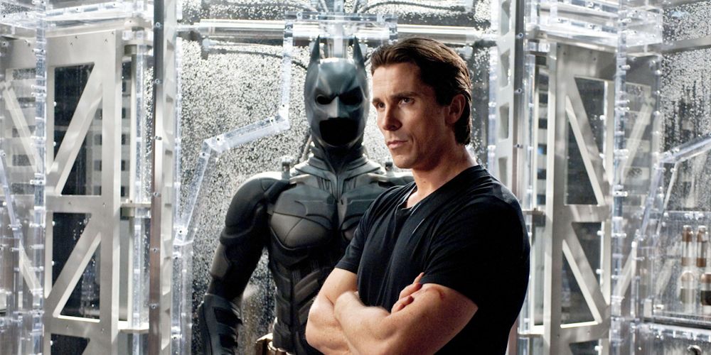 An image of Bruce Wayne standing in fron of the Batsuit in The Dark Knight Rises