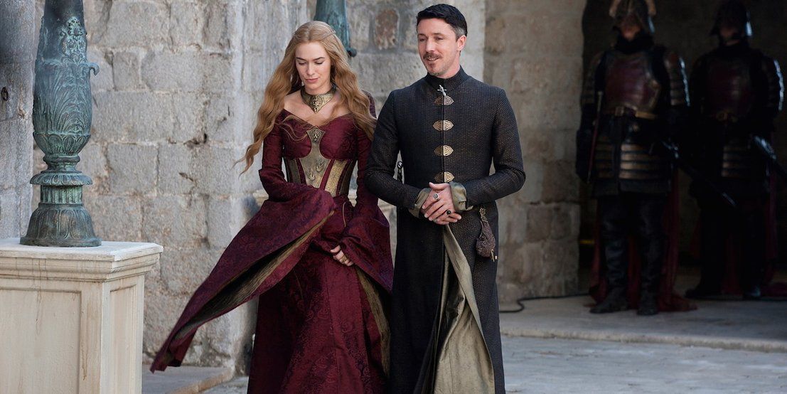 Cersei and Littlefinger walking together in Game of Thrones.