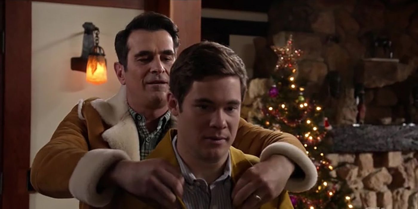 Phil from Modern Family wrapping a coat around Andy's shoulders