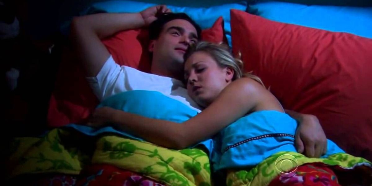 Leonard and Penny hugging in bed.