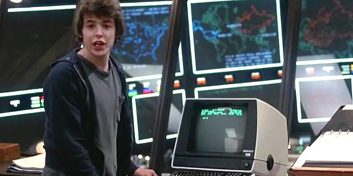 Caleb standing in front of a computer containing WOPR in the movie, WarGames