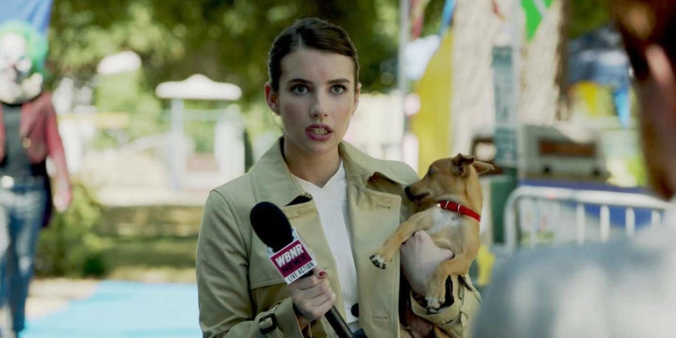 Serena Belinda holding a microphone and a Chihuahua while staring at someone with a confused expression in AHS Cult.