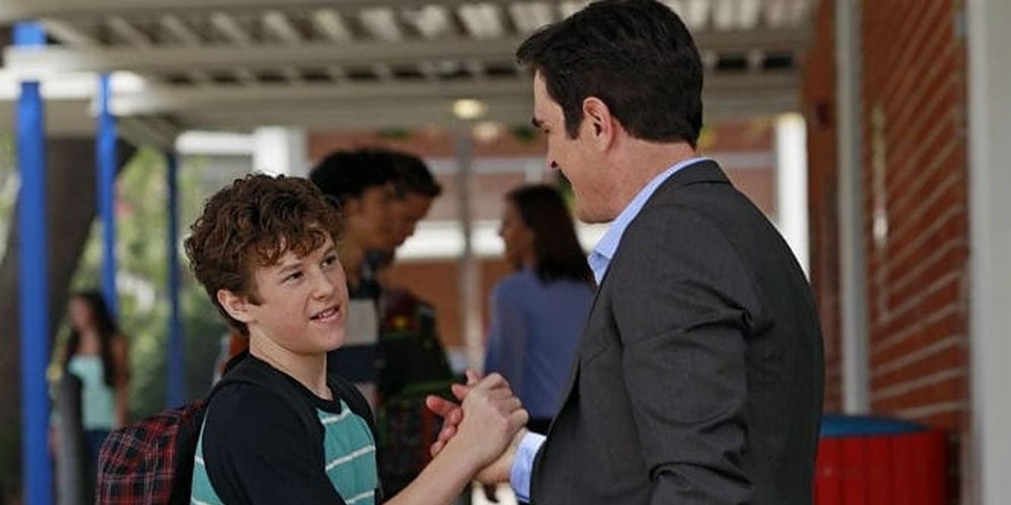 An image of Luke and Phil shaking hands in Modern Family