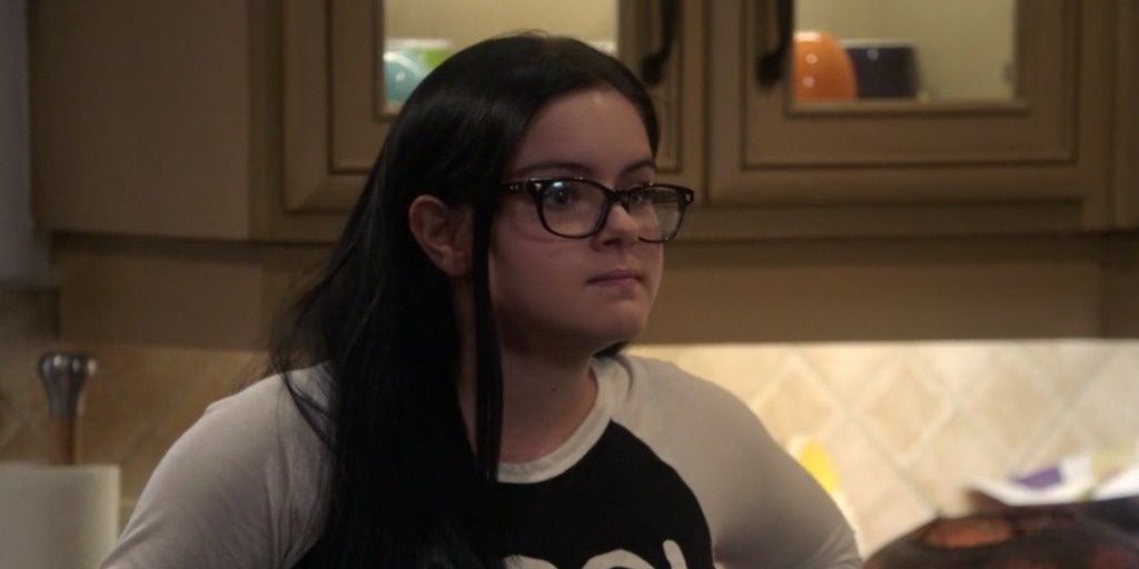 A close up of Alex on Modern Family, wearing a long-sleeved T-shirt and dark-rimmed glasses.