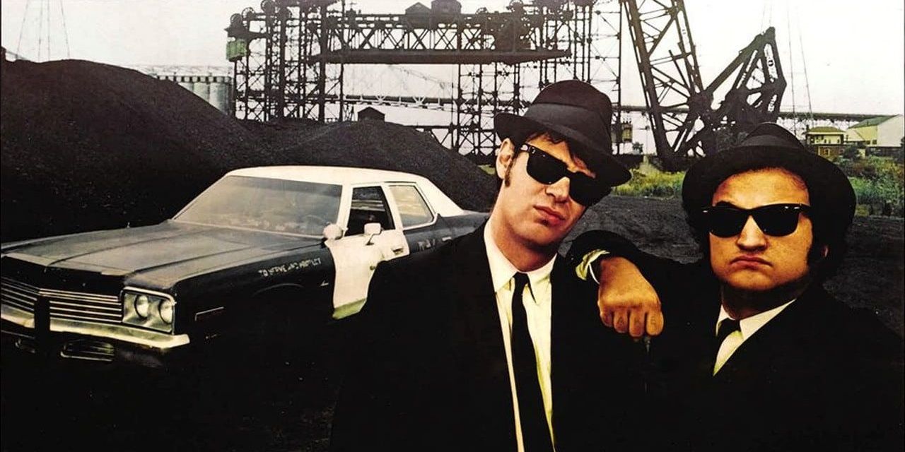 Jake and Elwood Blues standing in front of a car in The Blues Brothers