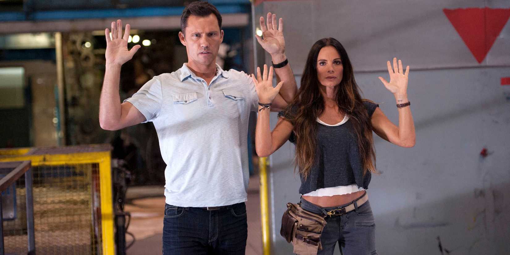 Michael and Fiona with their hands in the air in Burn Notice